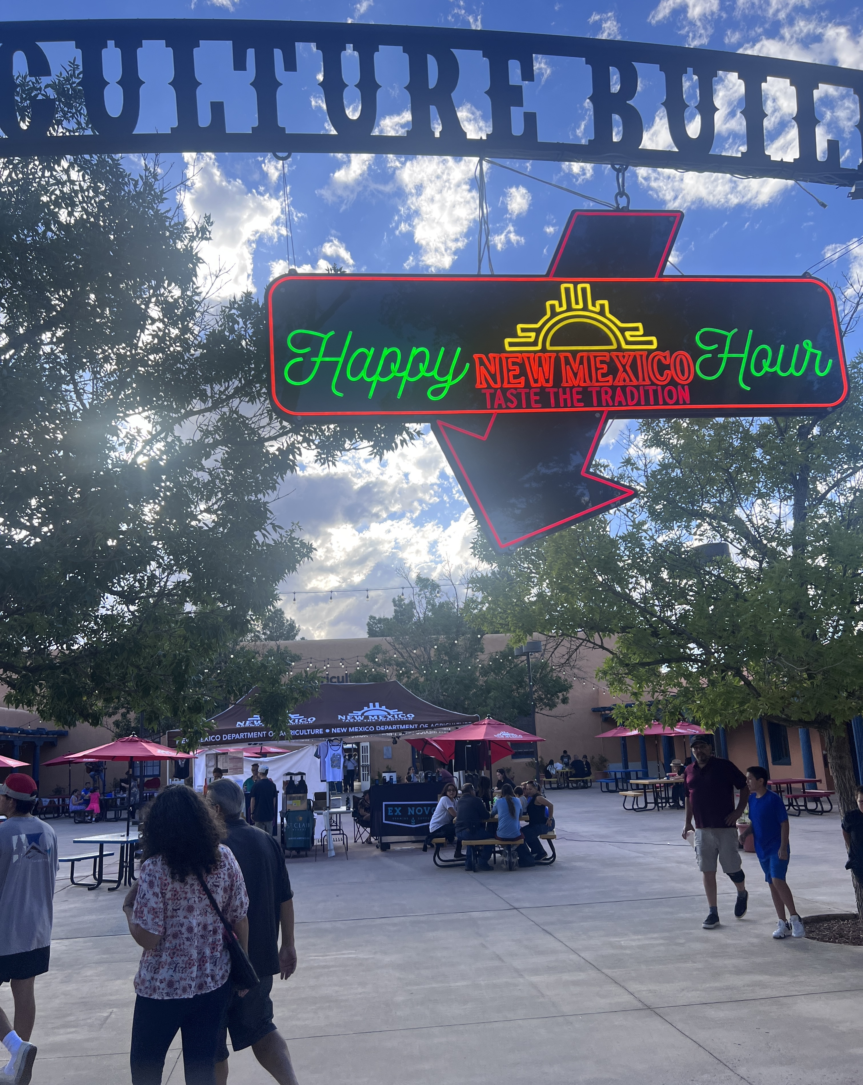 Happy Hour New Mexico Taste the Tradition neon sign hanging at the entrance of the New Mexico State fair.