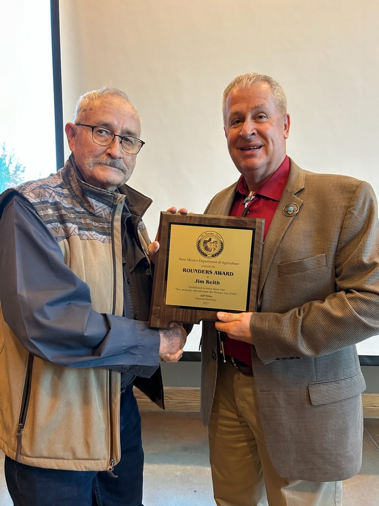 Two men shaking hands while holding a plaque.