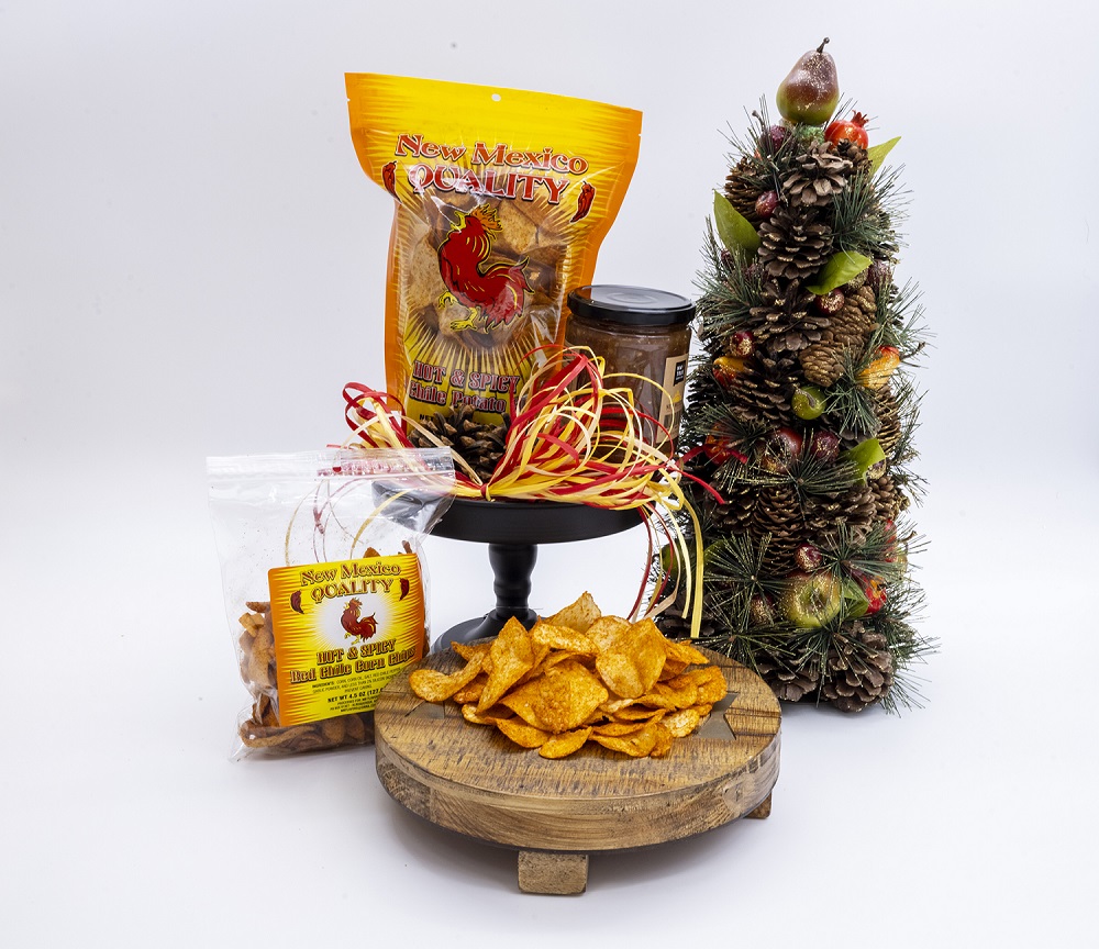 A Christmas scene filled with a Christmas tree and ribbon, chips and salsa are on display on a wooden stole.