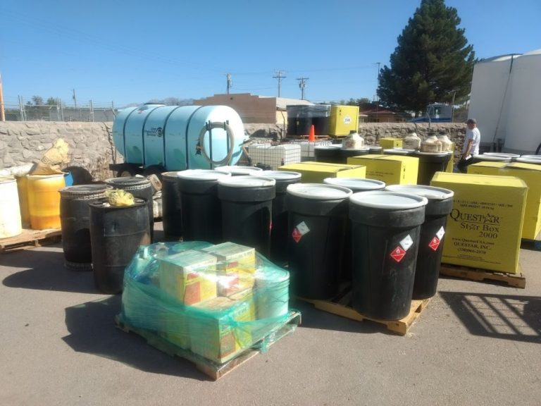 Blue and yellow containers of pesticides labeled with hazardous symbols.