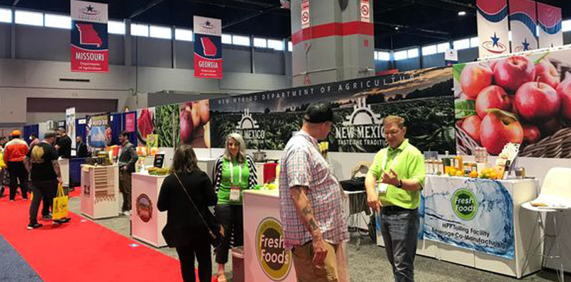 people attending a tradeshow and speaking to hosts. 
